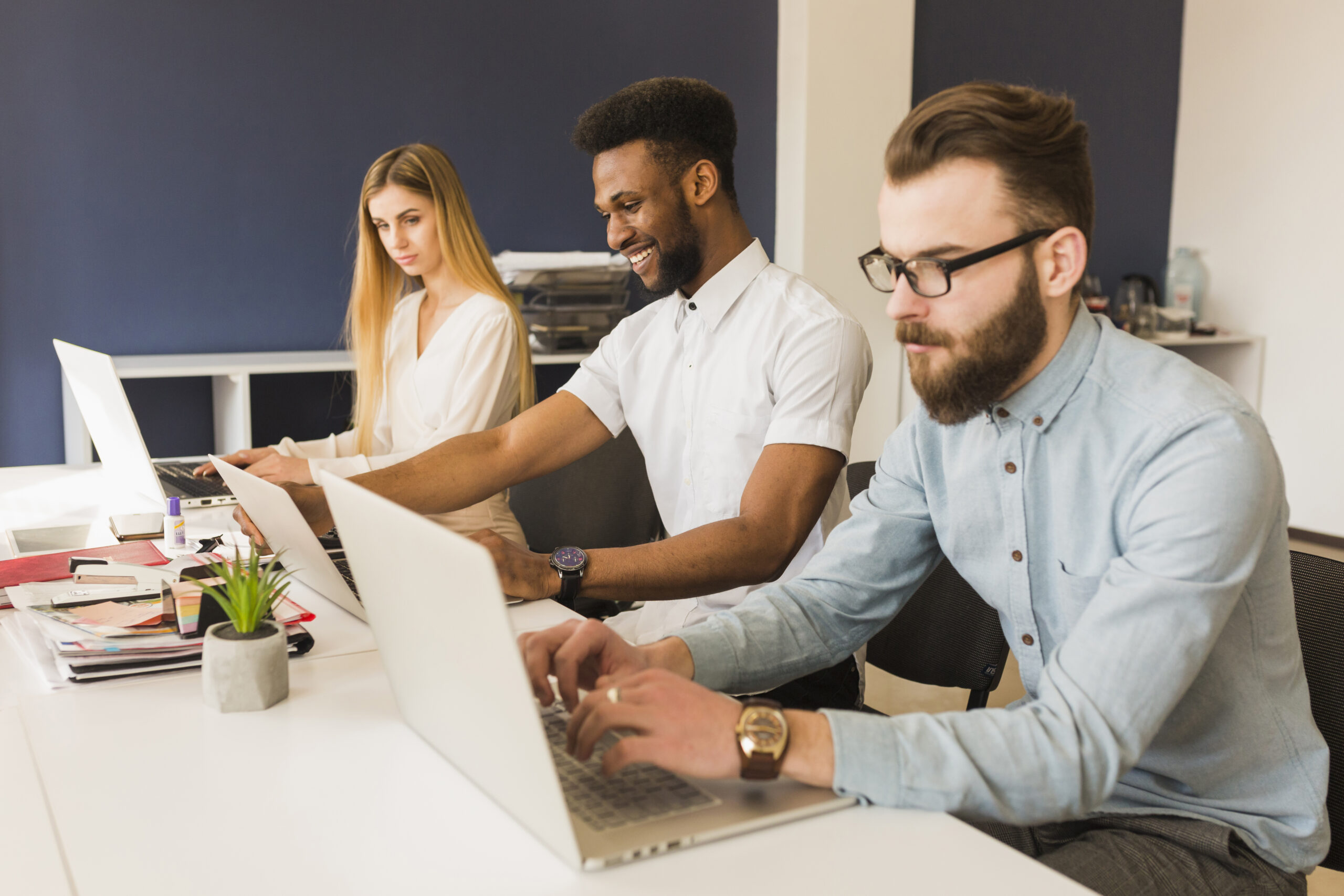 quem deve cuidar do site da empresa: dois homens e uma mulher trabalhando