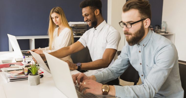 quem deve cuidar do site da empresa: dois homens e uma mulher trabalhando